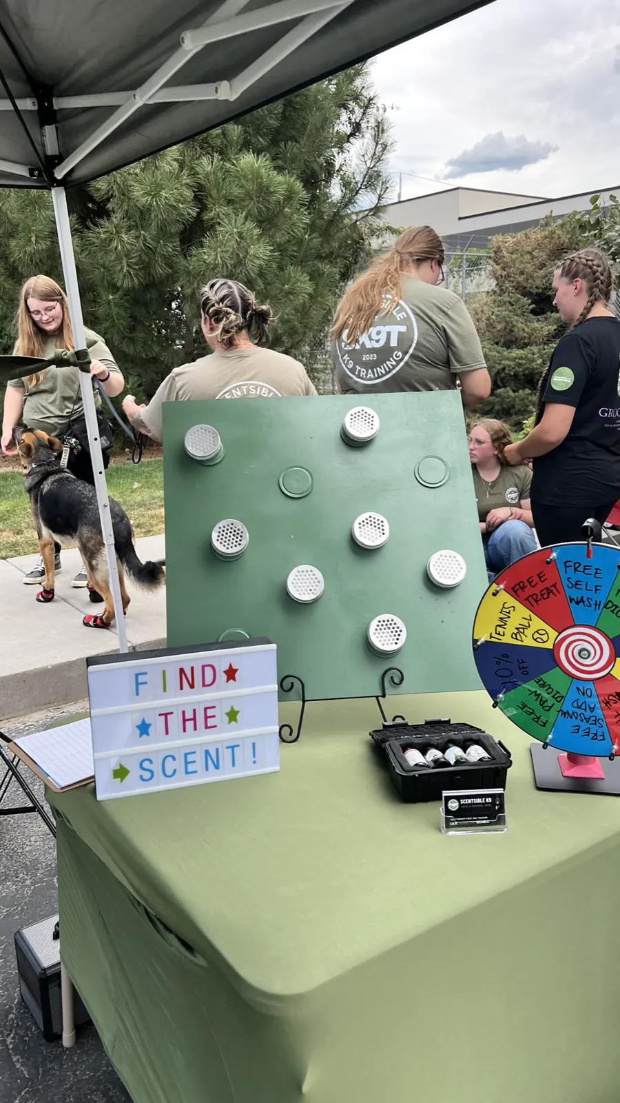 The Find the Scent game board and prize wheel set up on the Scentsible K9 booth table