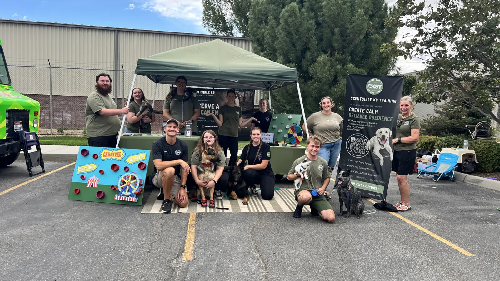The Scentsible K9 Training team and their dogs at an event booth in a Meridian parking lot